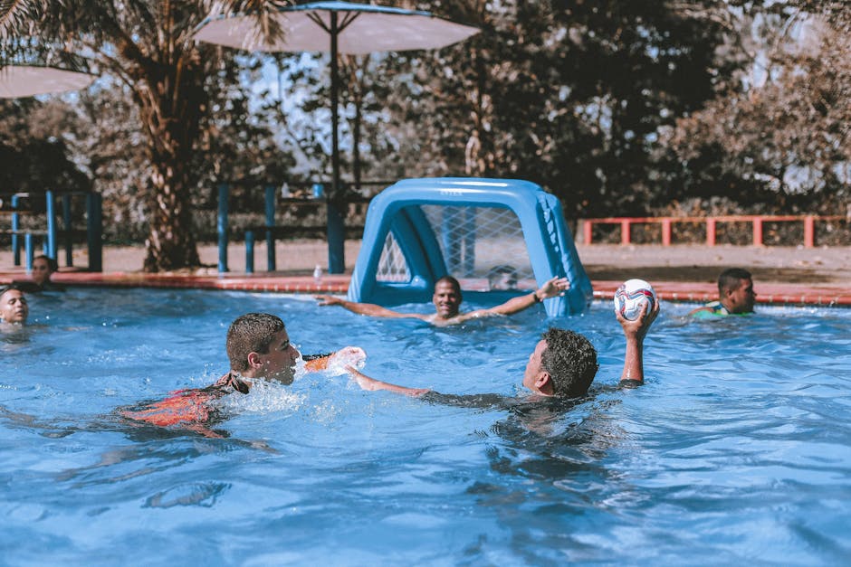 People on Swimming Pool Playing Ball