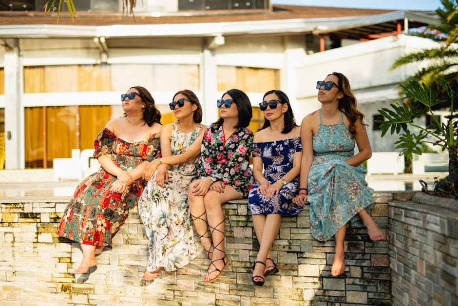 Women in Sunglasses and Sundresses Sitting on Wall