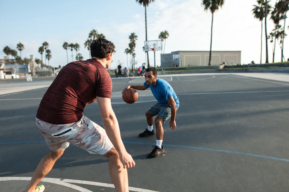 Dedicated diverse friends playing basketball on sports ground