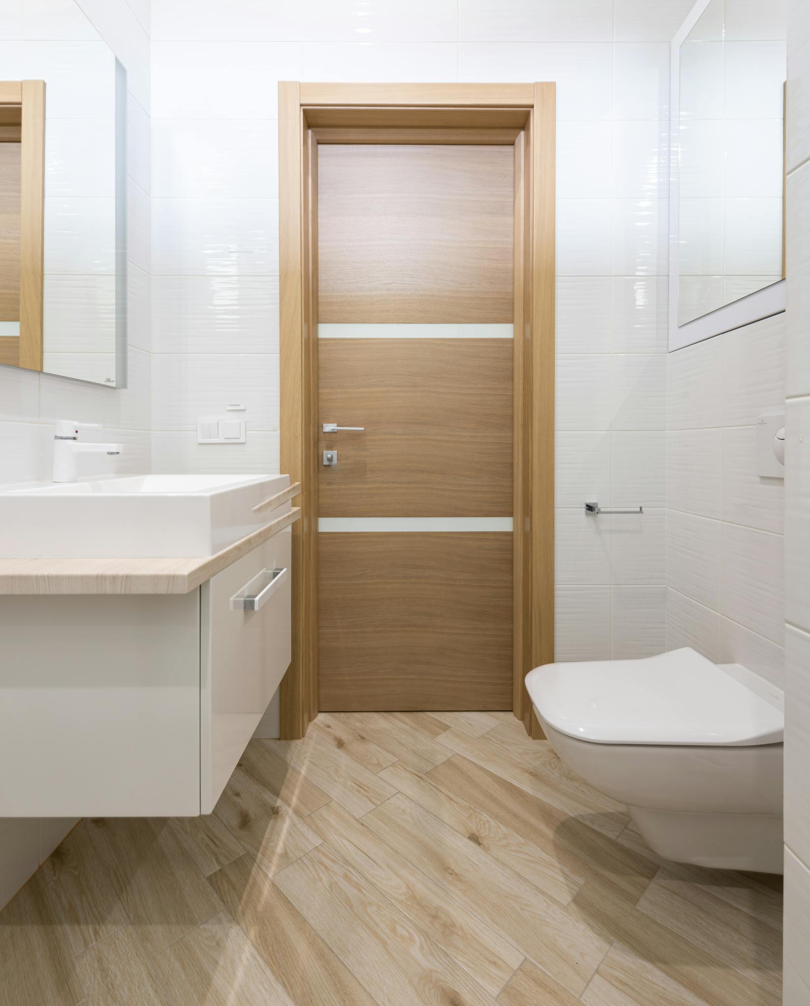 Wooden door of contemporary white bathroom