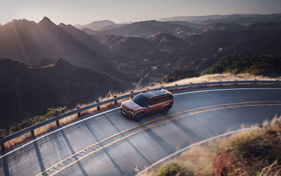 The Hyundai SANTA FE speeding around a corner on a mountain road.