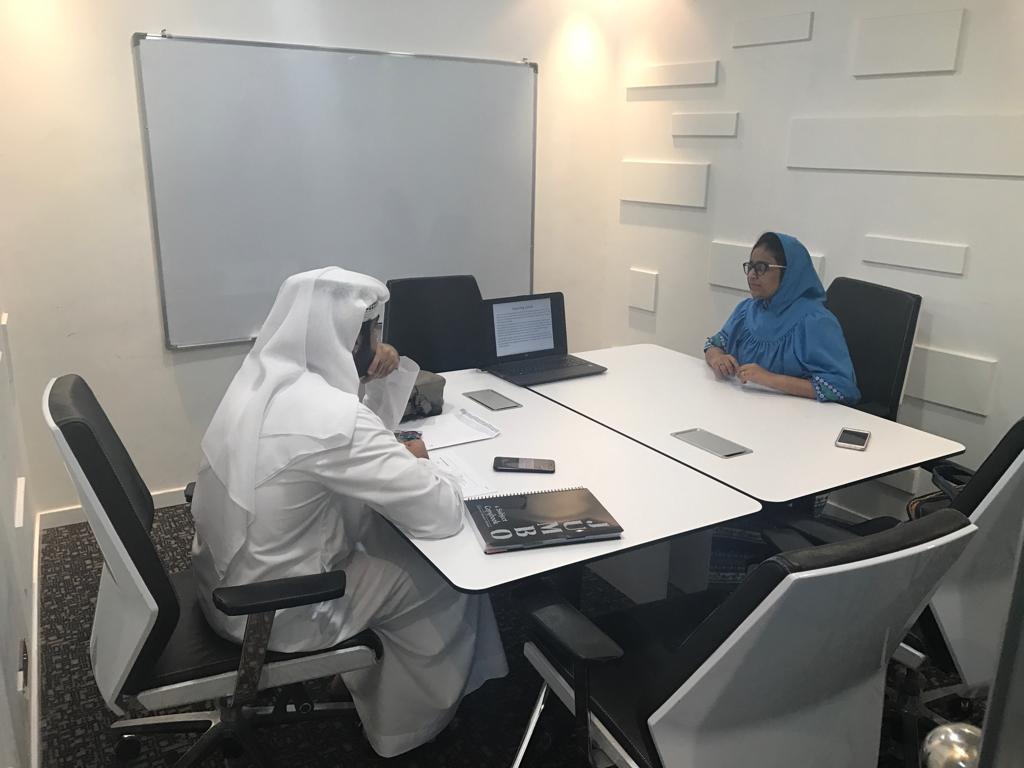 Young Woman in White Long Sleeve Shirt Holding Financial Book Report and Standing with Her Colleagues Inside an Office   