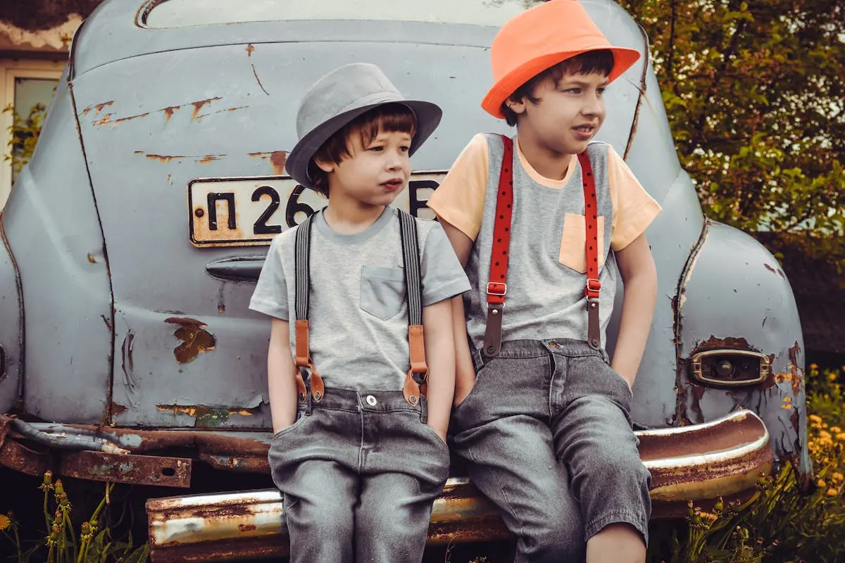 Two Boys Sitting on Vehicle Bumper