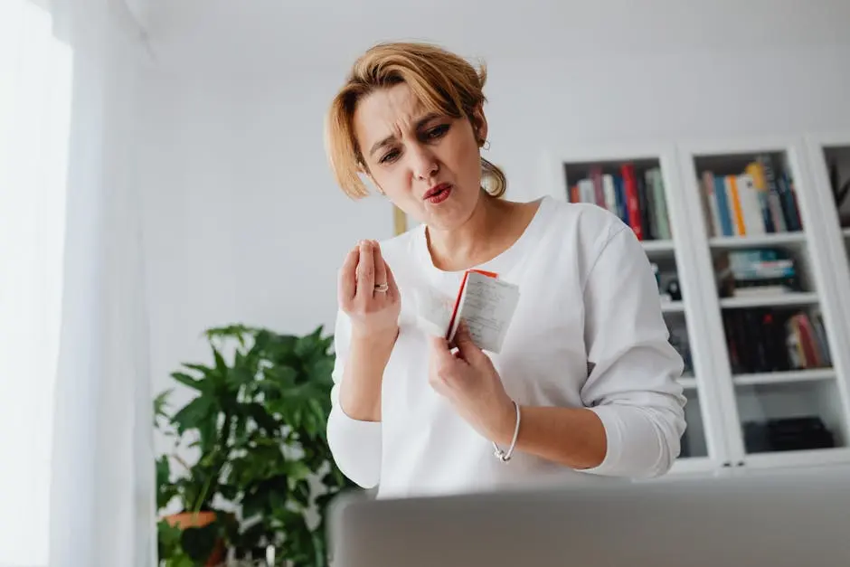 A concerned woman reviews her finances while holding receipts, showing a worried expression.