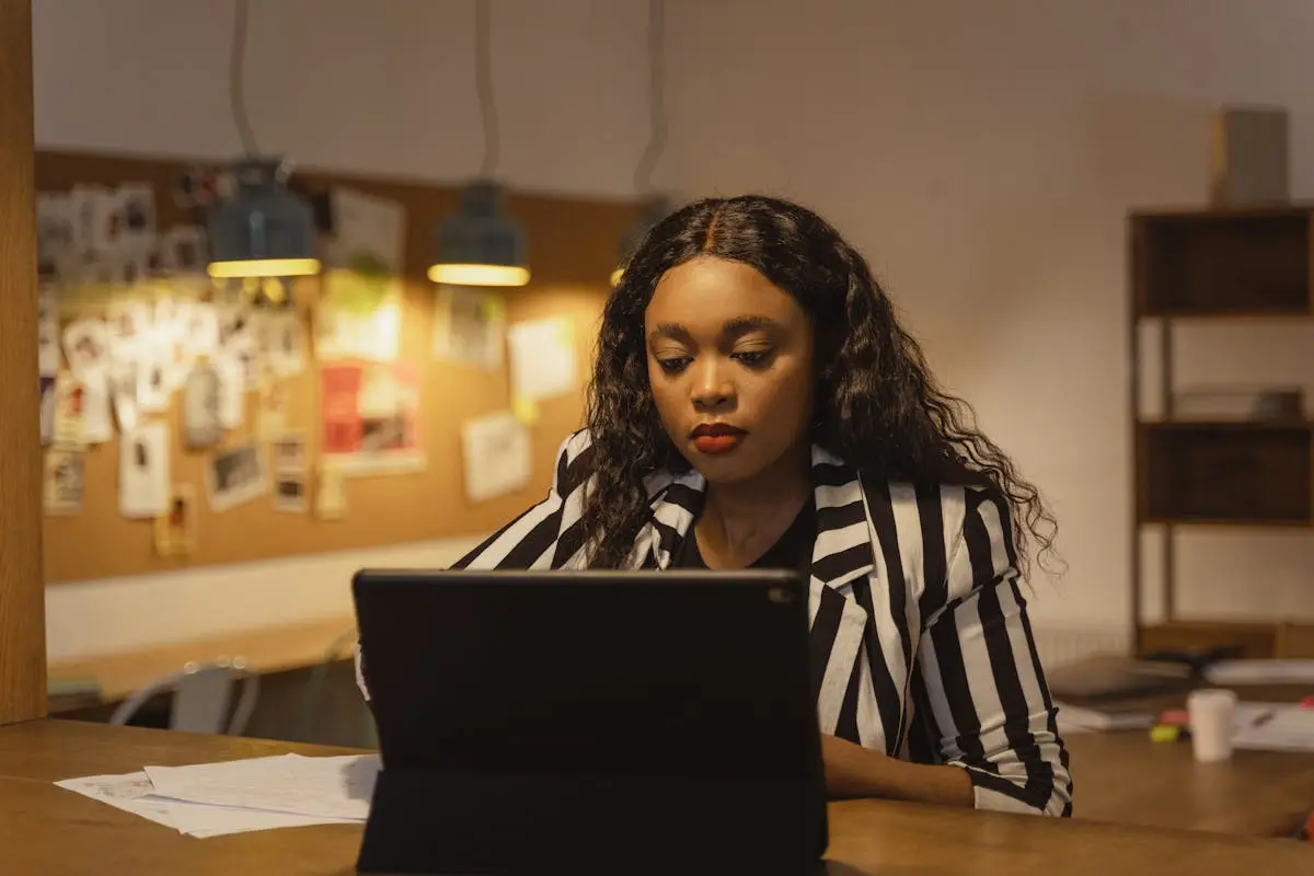 Photo of a Woman in a Striped Shirt Working