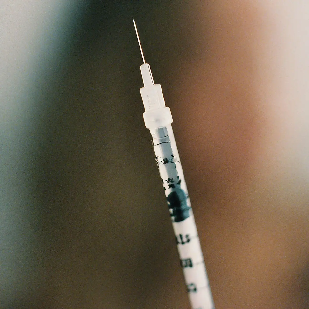 A close-up of a syringe with a soft-focus background. 35mm stock photo