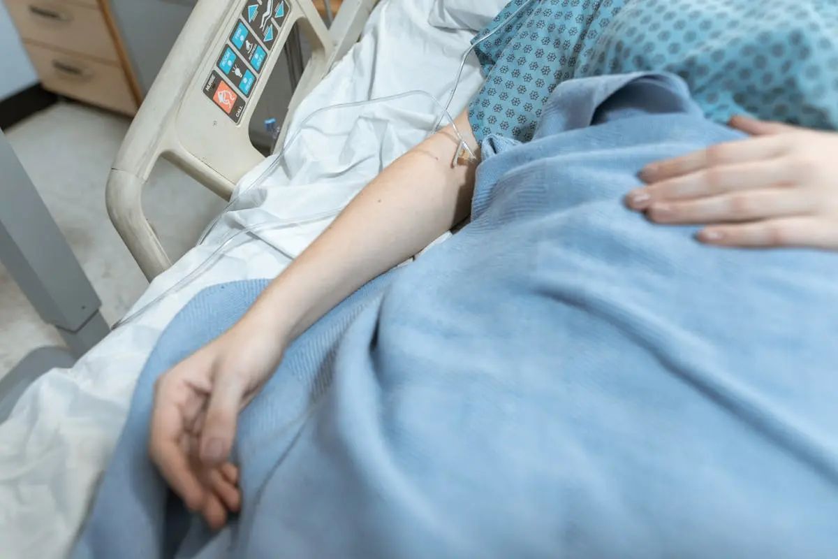 A close-up of a patient in a hospital bed receiving intravenous treatment, conveying healthcare and recovery.