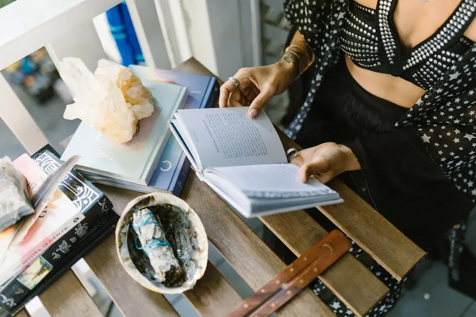 A person reads surrounded by crystals, sage, and books, creating a mystical atmosphere.