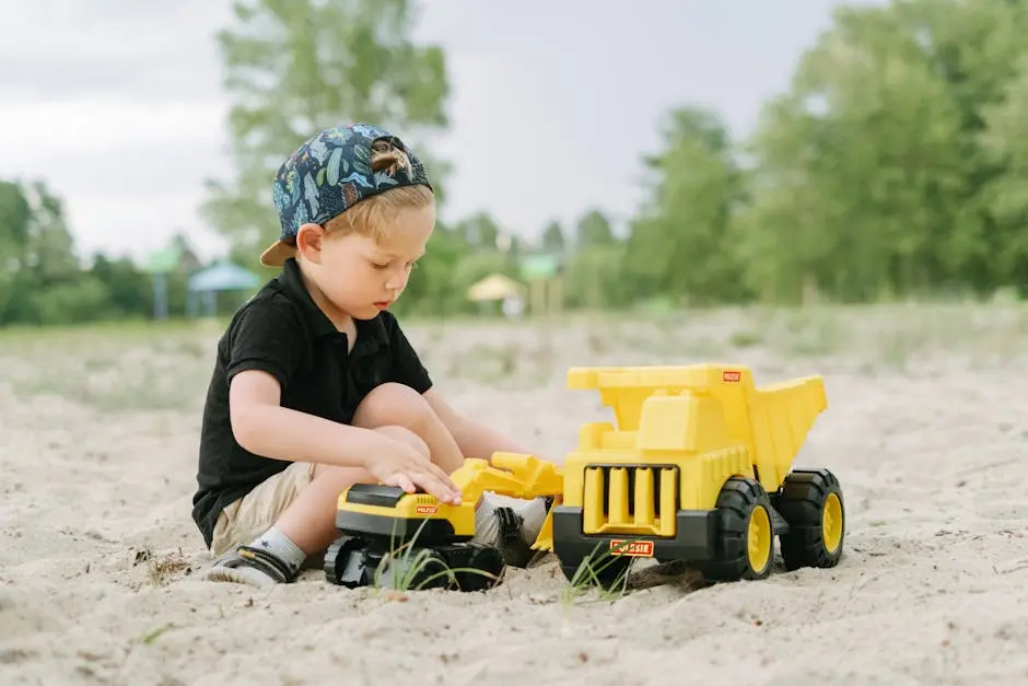 Young Boy Playing Toy Truck on a Sand