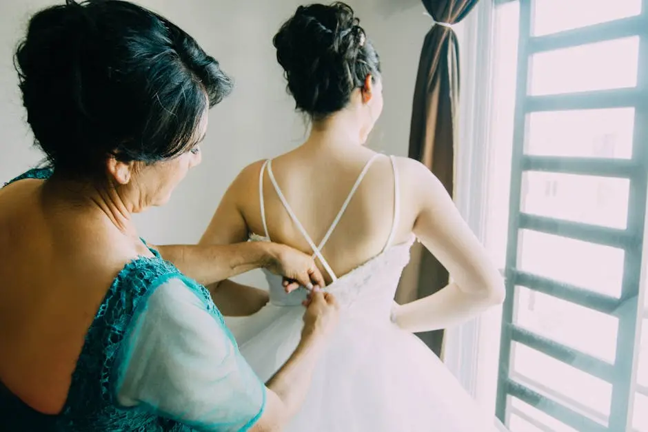 A Mother Zipping Up the Wedding Dress on Daughter