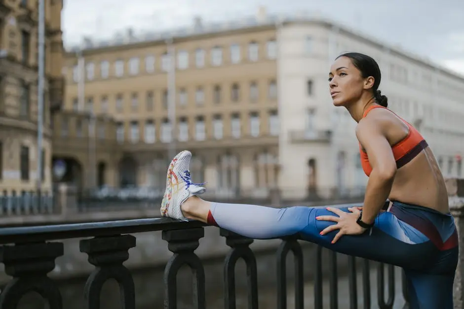 Woman stretching outdoors on urban street railing in activewear, promoting fitness.