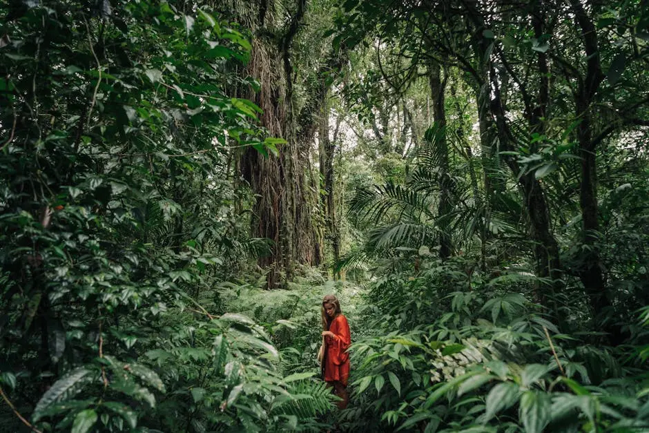 A woman in red walks through a lush tropical jungle, surrounded by green vegetation.