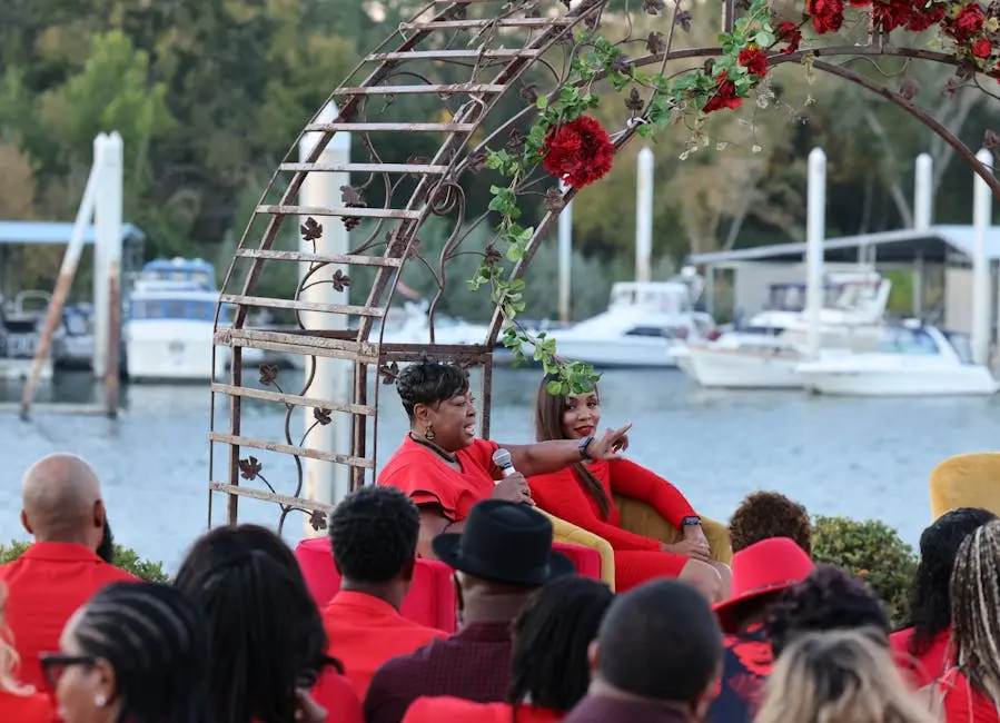 Outdoor event by a marina with speakers addressing the audience, mid-day.