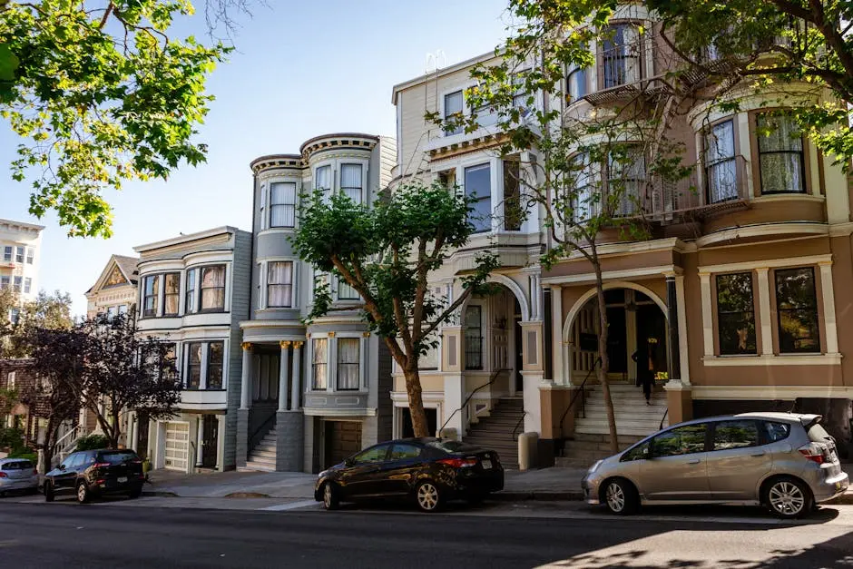 Cars parked near mansions in city residential district in sunlight