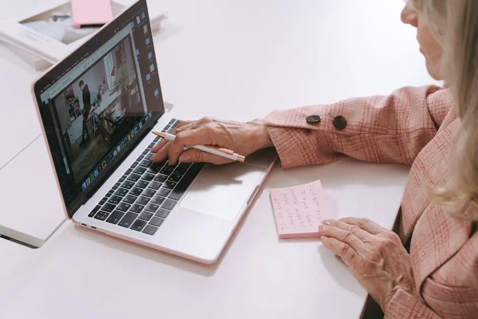 A Woman Taking Notes while Using a Laptop