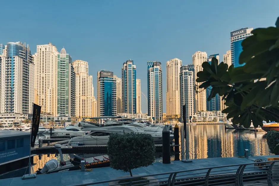 Panoramic view of Dubai Marina with luxury boats and iconic skyscrapers reflecting on the water.