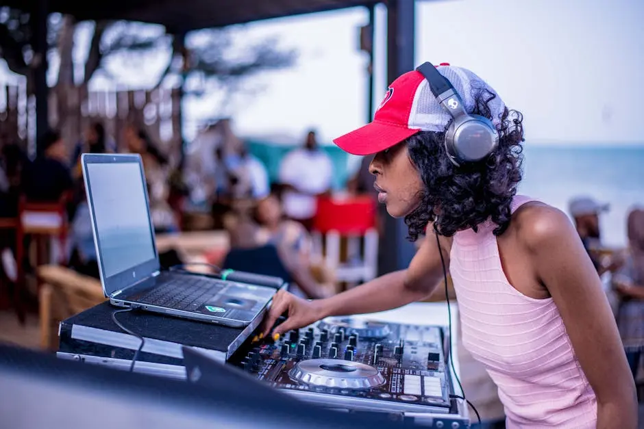 A female DJ with headphones mixing music at an energetic outdoor beach party.