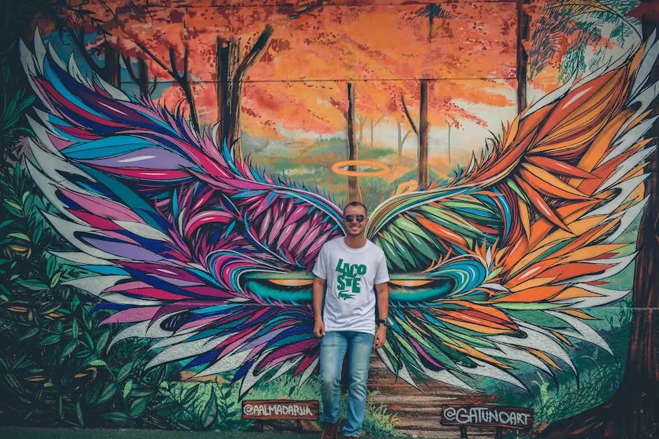 Man Wearing White and Green Crew-neck Shirt Leaning on  Graffiti Wall Art