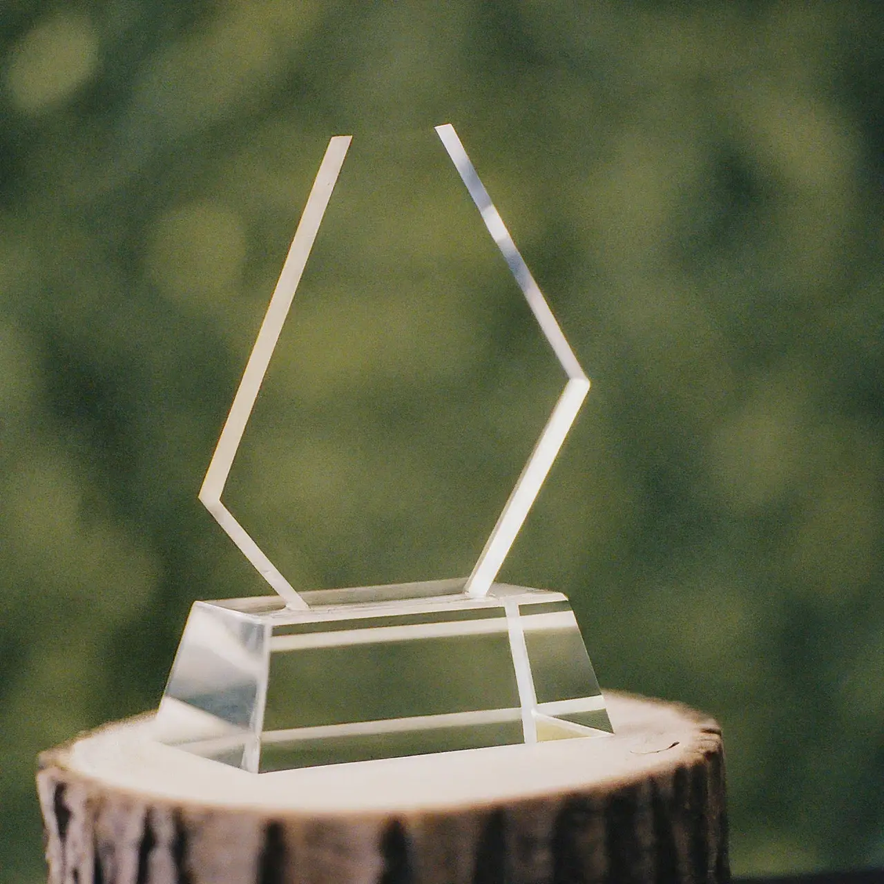 A shining acrylic trophy on a pedestal with a blurred background. 35mm stock photo