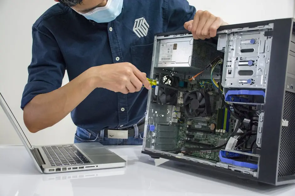 A technician repairs a desktop computer in an indoor setting, illustrating tech maintenance.