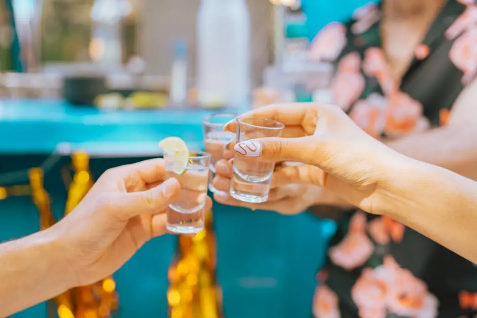 Close-Up Shot of People Holding Glasses of Tequila