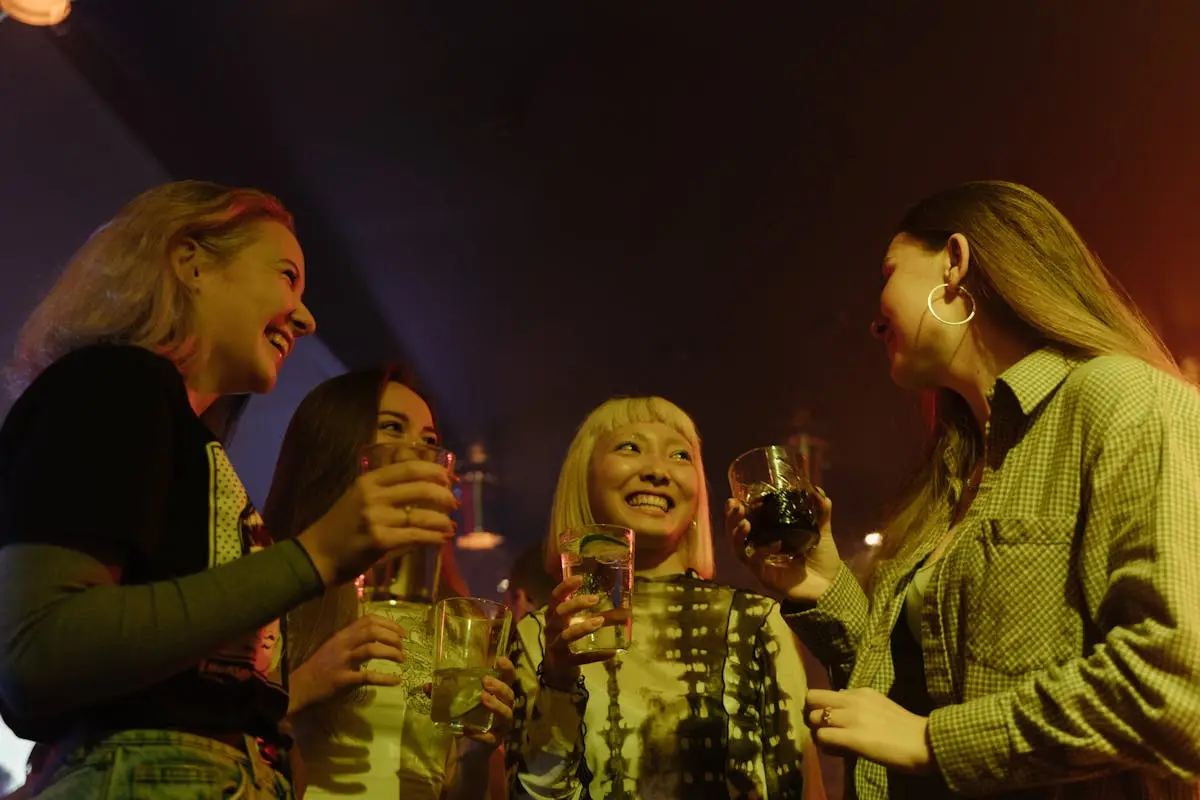 A joyful group of friends celebrate and enjoy drinks at a lively nightclub.