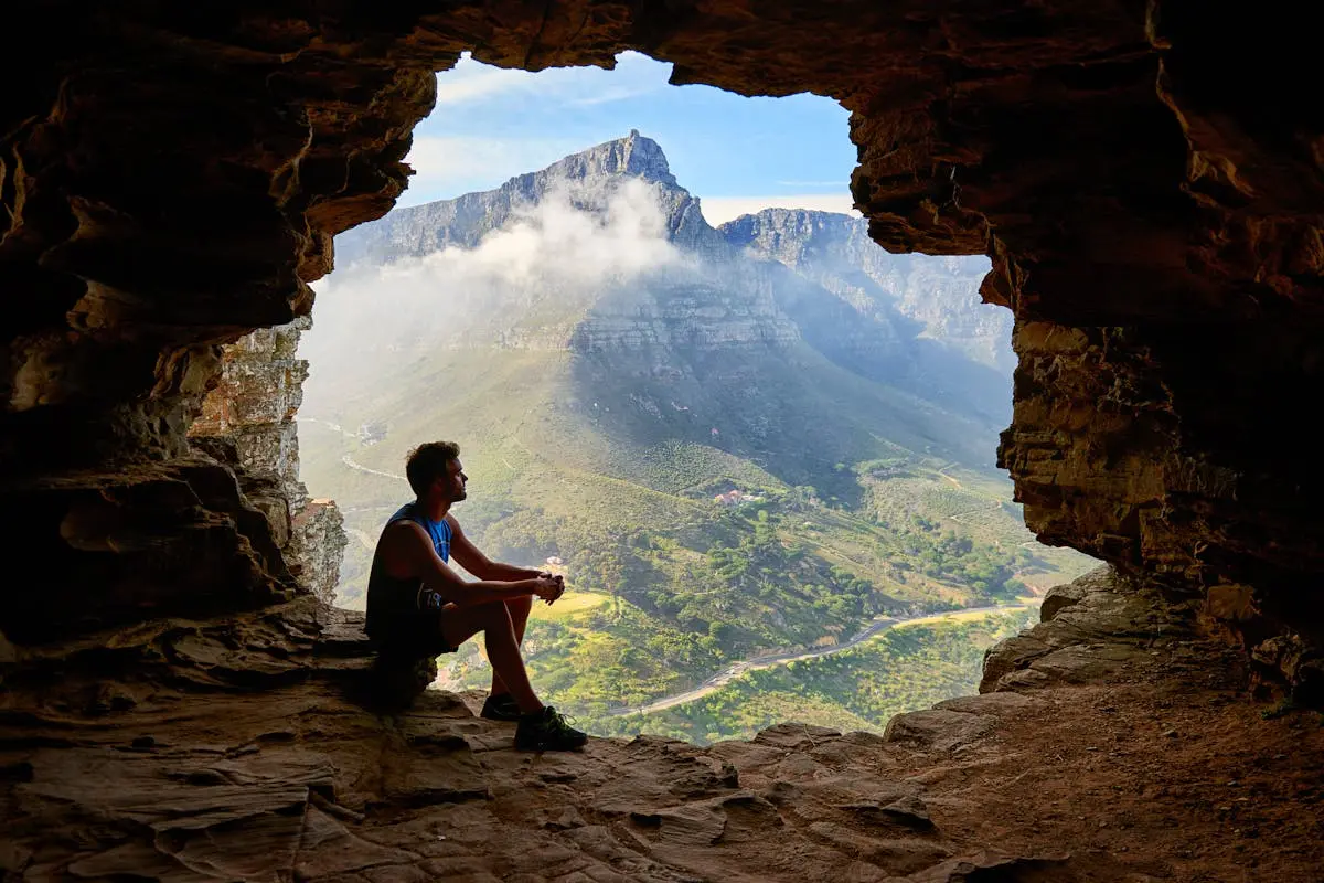 Photo of Man Sitting on a Cave 