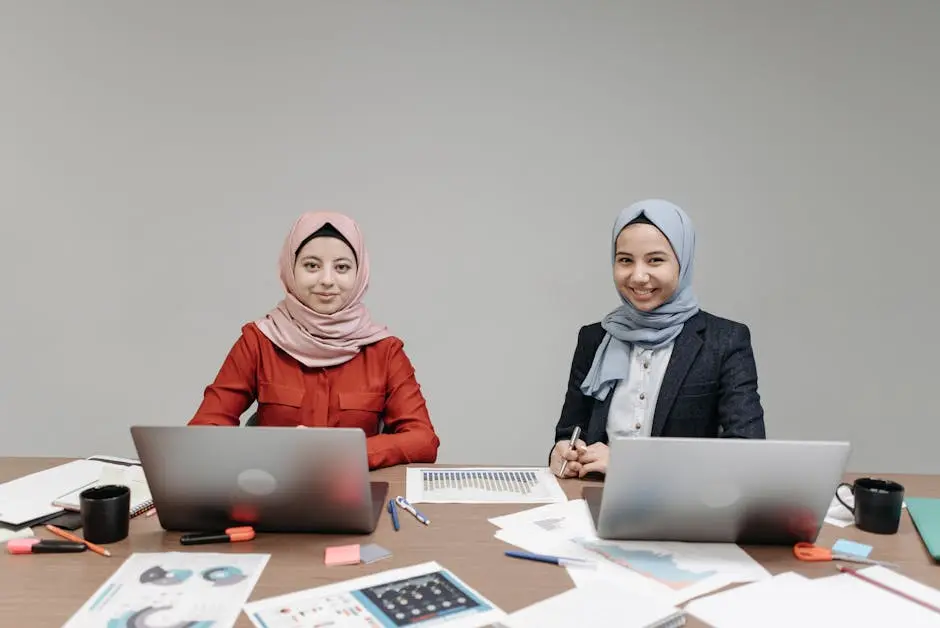 Women in Hijabs in Front of Laptops on a Wooden Table