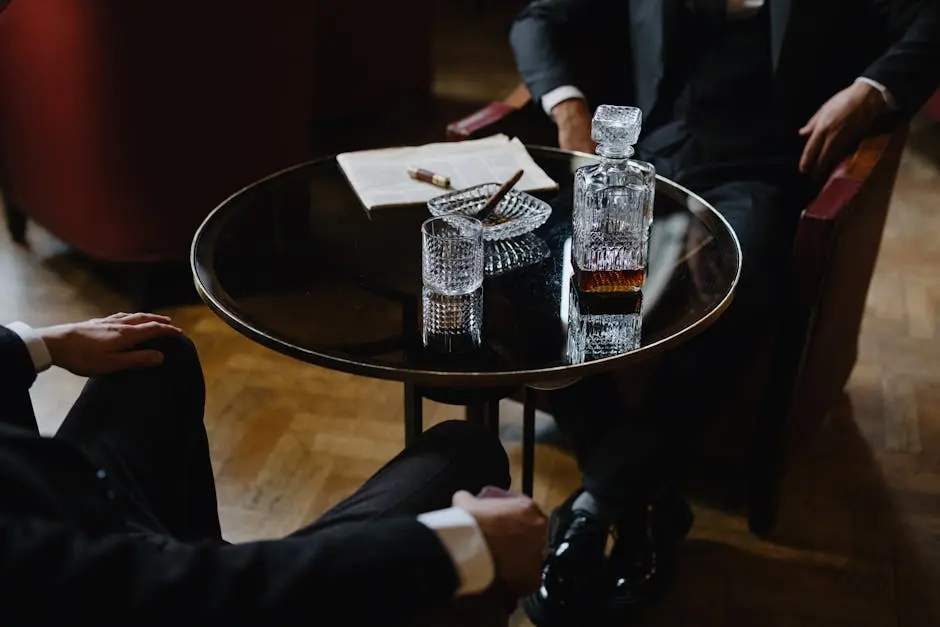 Two men in suits at a bar table with whiskey and cigars, creating a classic ambiance.