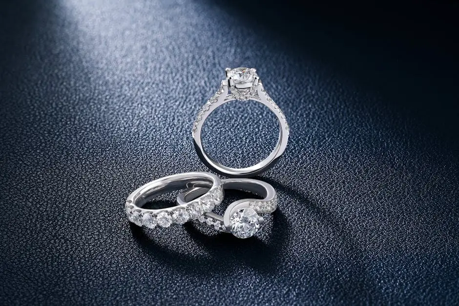 Close-up of luxurious diamond engagement and wedding rings on a textured surface, showcasing elegance and craftsmanship.