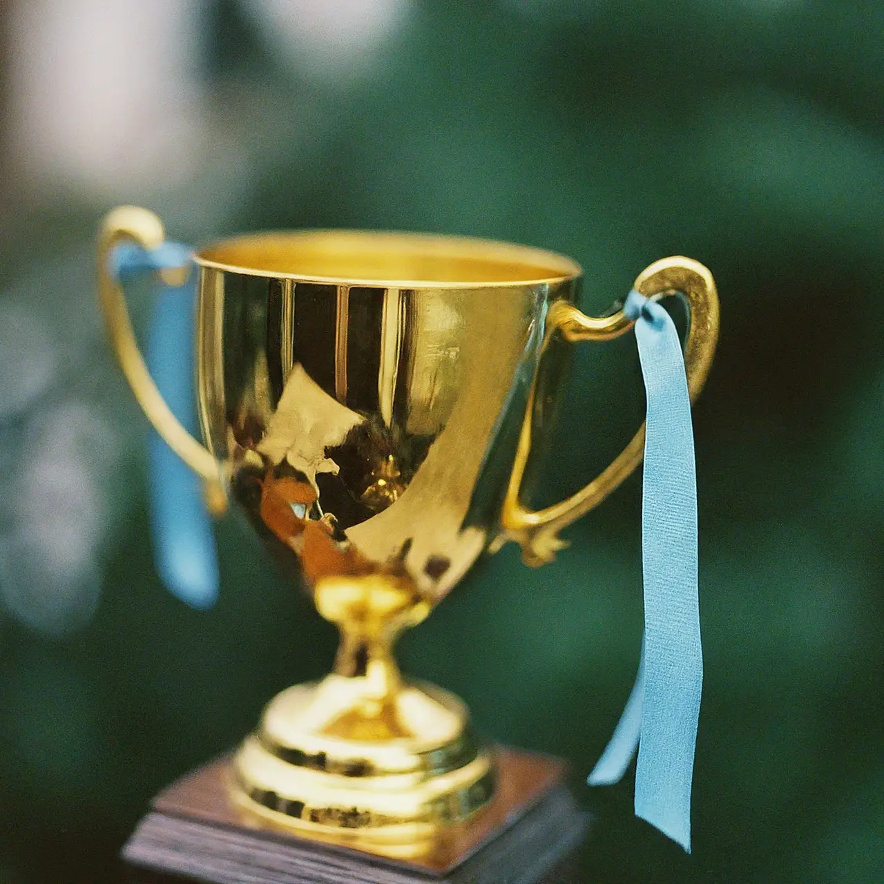 Close-up of a golden trophy with a blue ribbon. 35mm stock photo