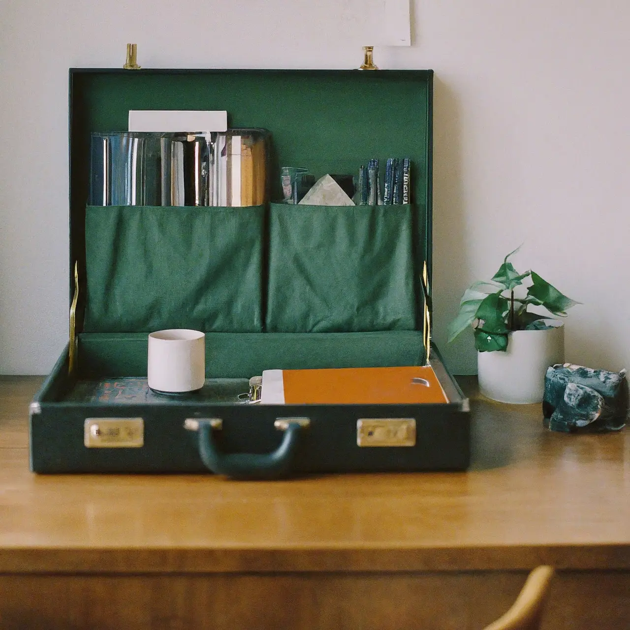 A briefcase next to a neatly organized desk. 35mm stock photo