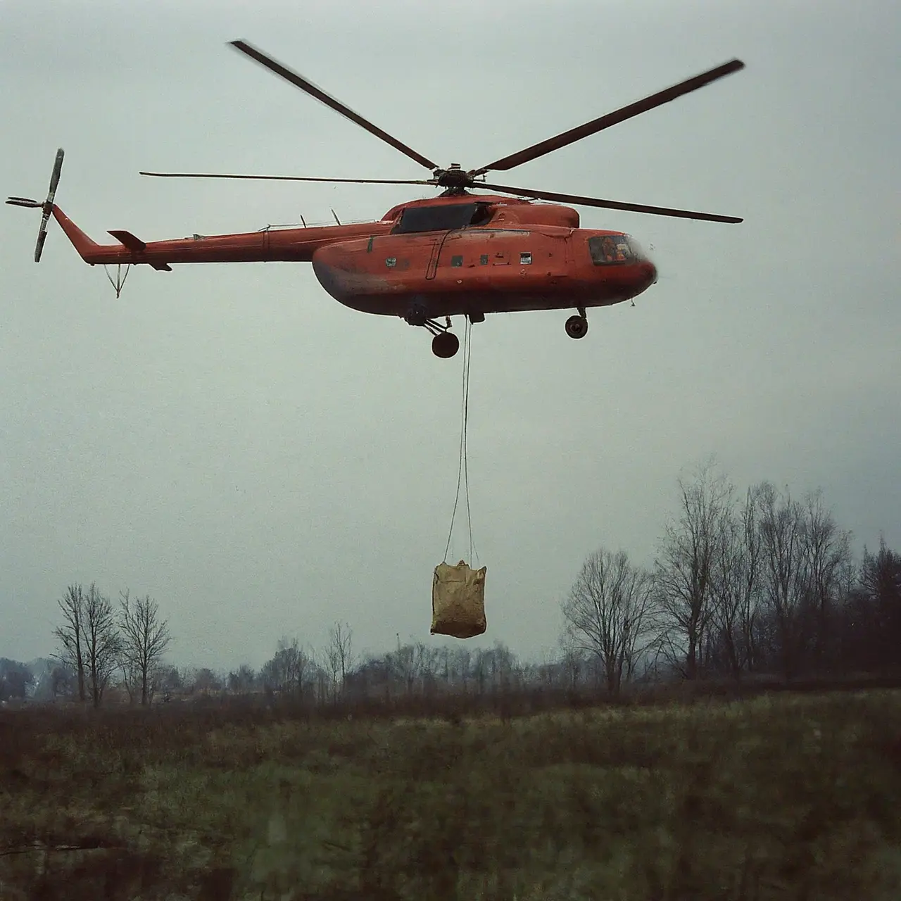 Helicopter dropping supplies in disaster-stricken area. 35mm stock photo