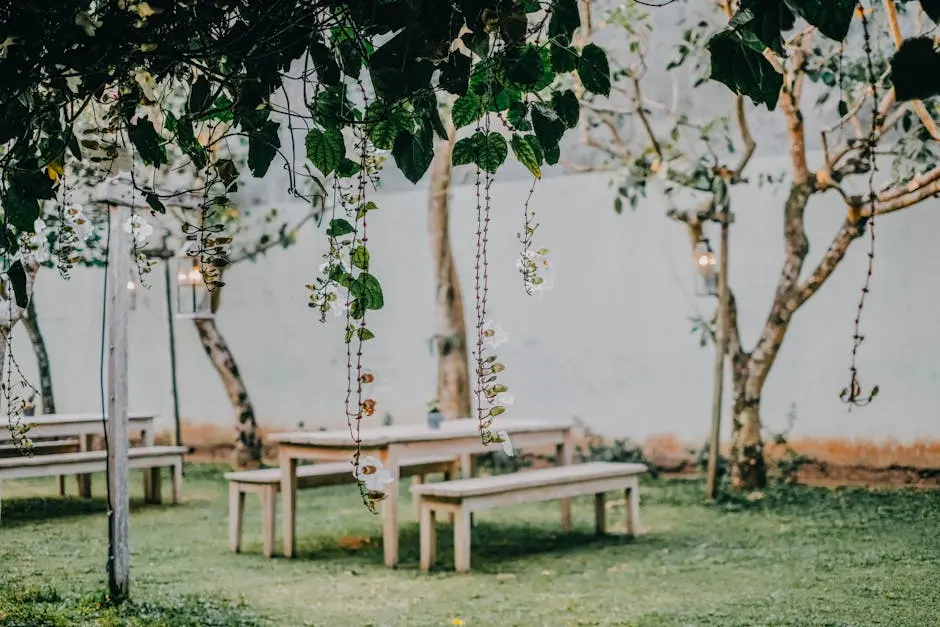 Peaceful garden setting featuring wooden benches and tables under a lush vine arbor.