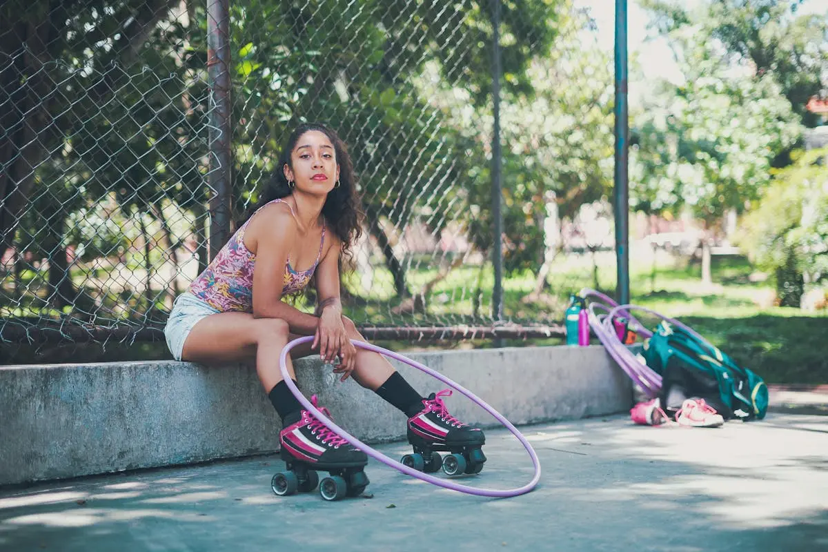 A Woman Wearing Roller Skates Sitting on a Concrete Surface