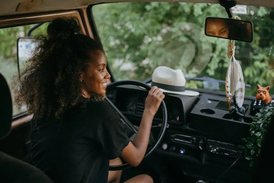 Woman driving a van through nature, enjoying a summer road trip journey.