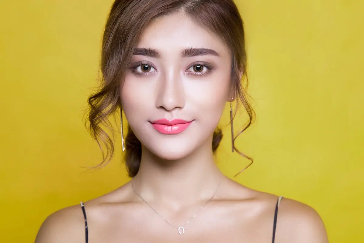 Beautiful portrait of a woman with elegant hairstyle on a vibrant yellow background.