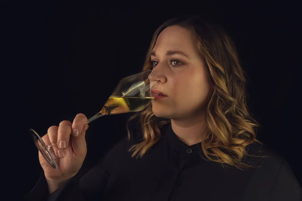 Emotionless woman smelling aromatic white wine