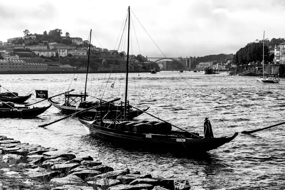 Black and white image of traditional boats on Douro River, Porto, Portugal.