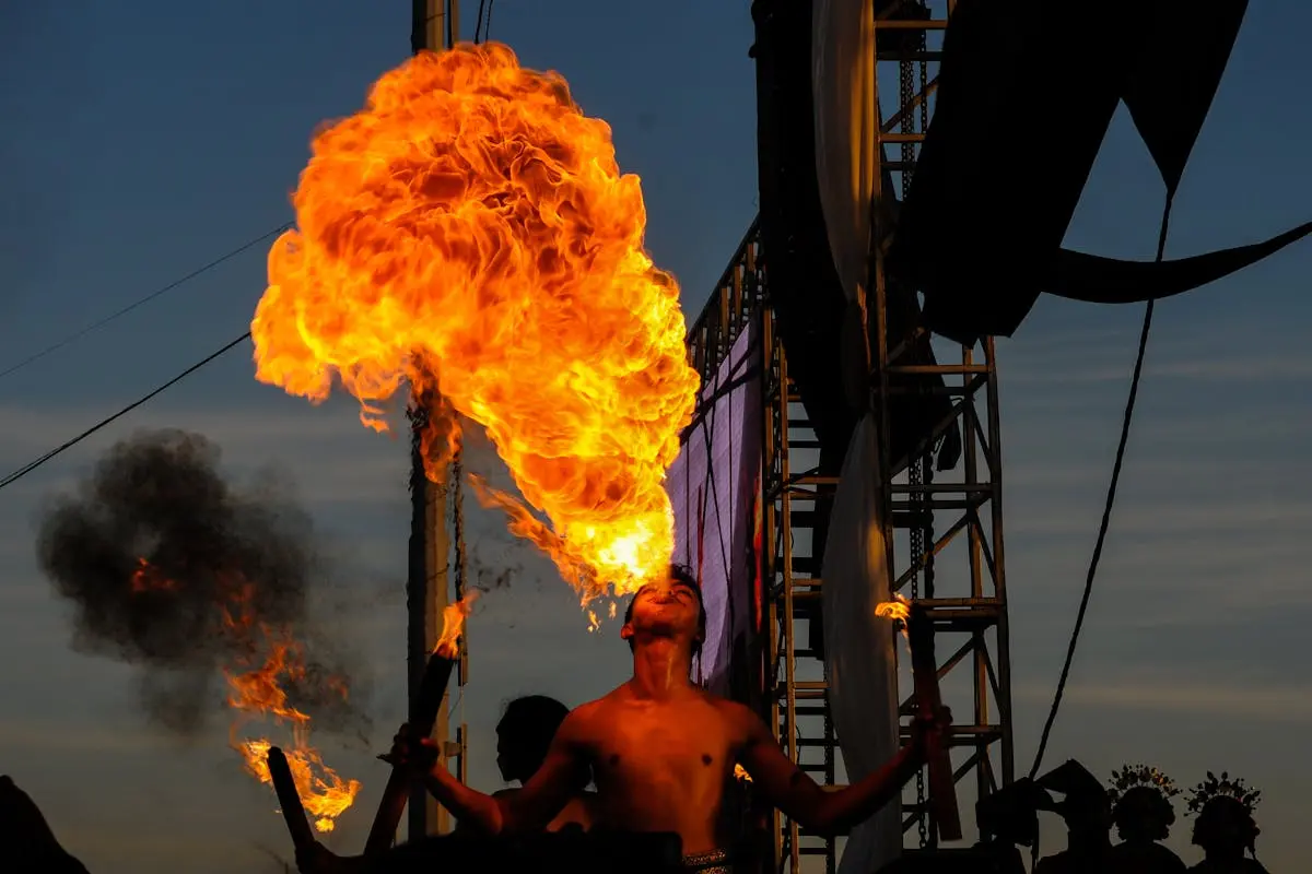 Spectacular fire breather performing outdoors at night, showcasing fiery skill and artistry.