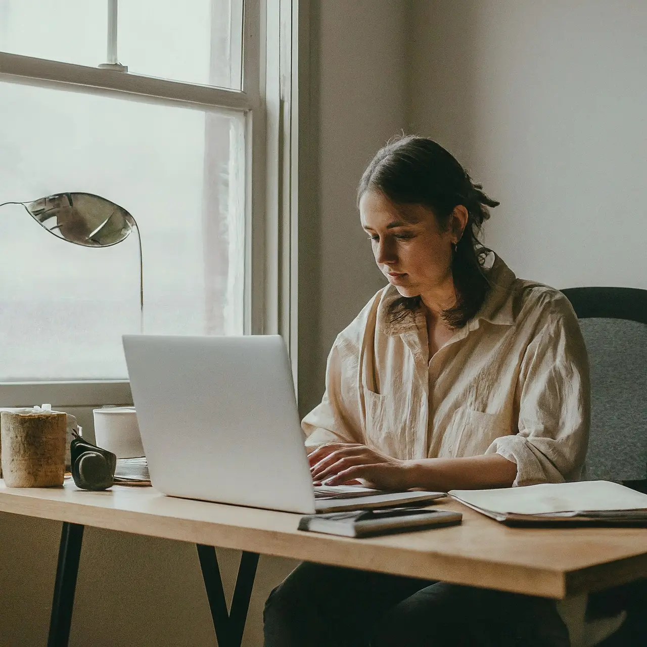 A small business owner working on a laptop in a cozy office. 35mm stock photo