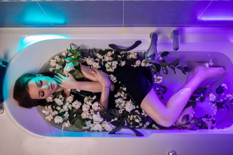 Woman soaking in a bathtub filled with white roses, creating a tranquil and aesthetic mood.