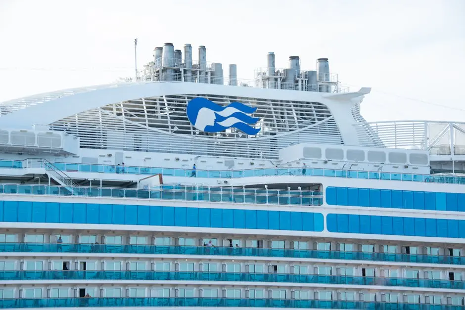 Detailed view of a modern cruise ship’s upper deck with visible cabins and chimneys.