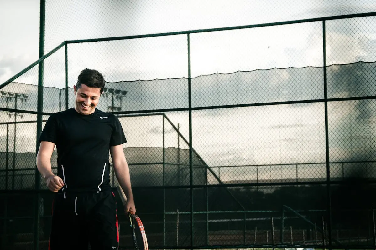 Man Wearing Black Nike Dri-fit Shirt Holding a Tennis Racket