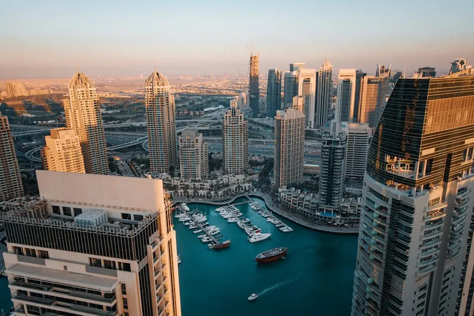 Stunning aerial view of a modern marina and skyscrapers under a sunlit sky.