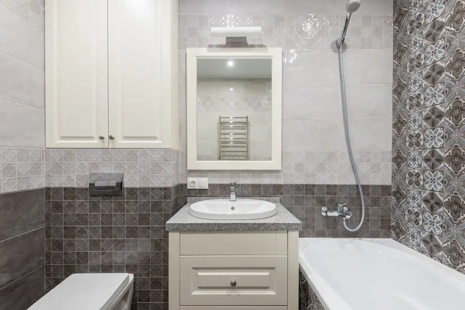 A stylish bathroom featuring a ceramic sink, bathtub, and decorative tiles with ample cabinet storage.