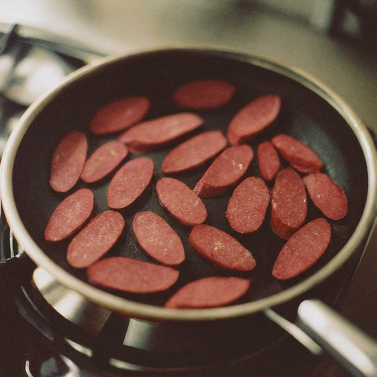 Sucuk slices cooking on a pan. 35mm stock photo