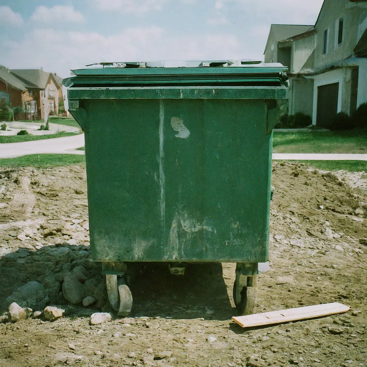 A small dumpster on a residential construction site. 35mm stock photo