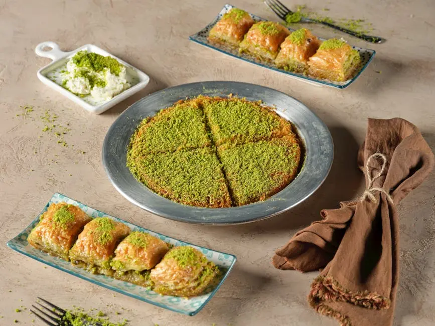 A selection of traditional Turkish desserts, including baklava and kunafa, garnished with pistachios.