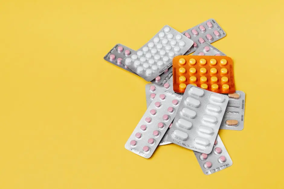 Various pills in blister packs on a yellow background, ideal for health-related themes.